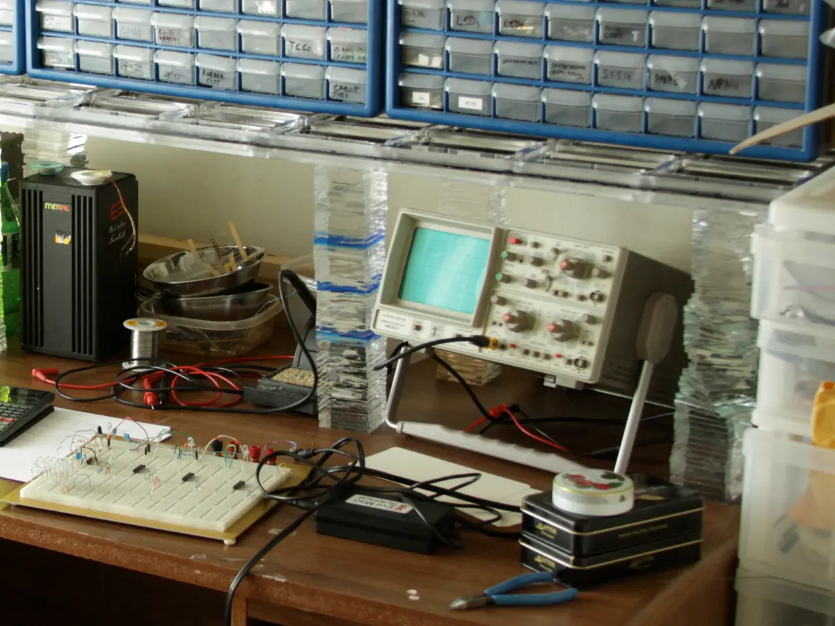 Electronics test bench with an oscilloscope, breadboard circuit and probes, used for firmware and hardware testing